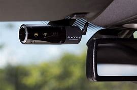 Close up of a dash front facing camera positioned next to the rear view mirror